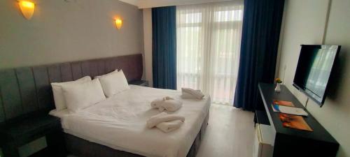a hotel room with a bed with towels on it at Vanna Hotel Spa in Hamamözü