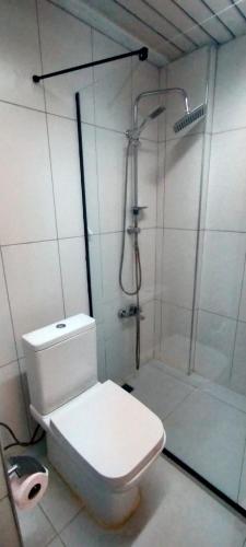 a white bathroom with a shower and a toilet at Vanna Hotel Spa in Hamamözü