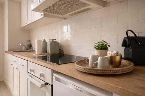 un bancone della cucina con un vassoio di tazze sopra di SLEEP INN - Arizona flat with cityview ad Anversa