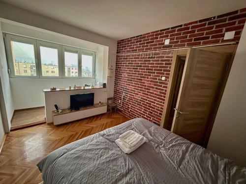una camera da letto con un muro di mattoni e un letto di Tilia a Zaječar