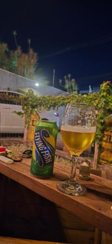 a glass of beer and a can on a table at Hostel Barato Zona Sul in Porto Alegre