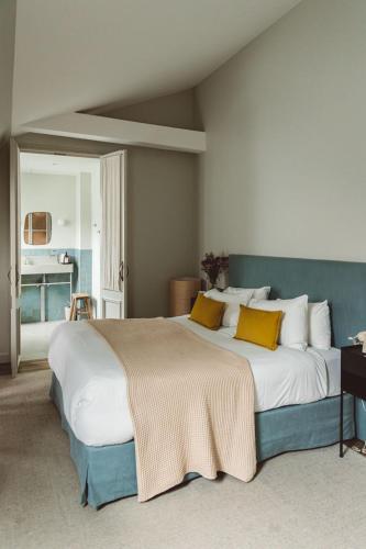a bedroom with a large white bed with yellow pillows at HOY Paris - Yoga Hotel in Paris