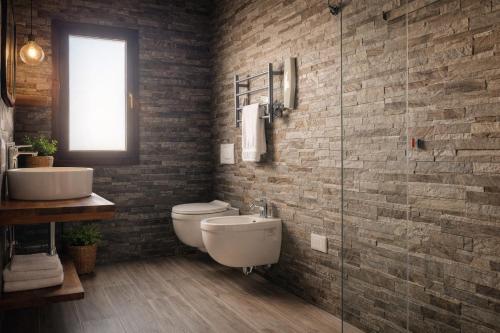 une salle de bains avec toilettes et lavabo dans l'établissement residence Sant'Anna i4MORI, à SantʼAnna Arresi