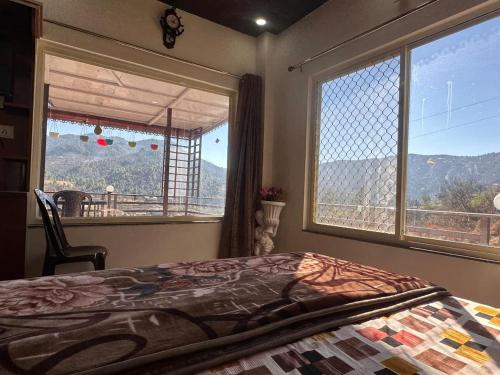 a bedroom with a bed and a large window at Mount view guest house in Mukteshwar
