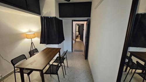 een eetkamer met een houten tafel en stoelen bij The Nook in Pondicherry