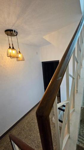 een trap met een kroonluchter en een witte muur bij The Nook in Pondicherry