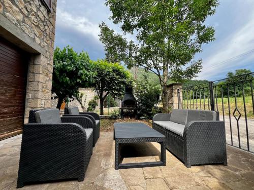 a patio with four chairs and a table and a grill at Casa de Muntanya per desconectar in San Julián de Cerdanyola