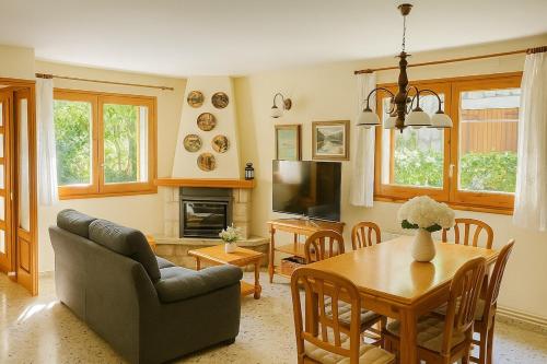 a living room with a table and a dining room at Casa de Muntanya per desconectar in San Julián de Cerdanyola