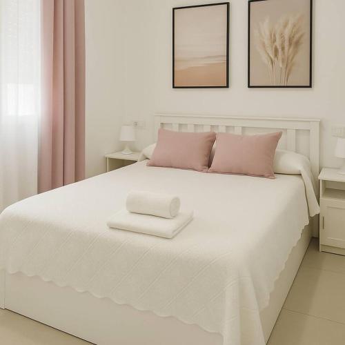 a white bed with two white towels on it at Alojamiento Baeza California 2B in Baeza