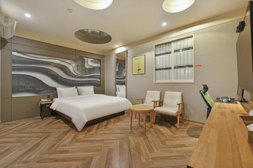 a hotel room with a bed and a table and chairs at Palace Hotel in Ulsan