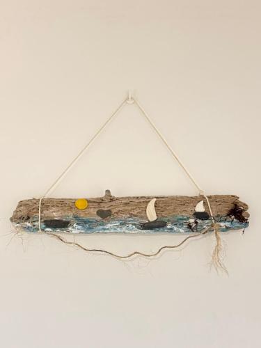 a piece of driftwood hanging on a wall at Atlantic Breeze Apartment in Figueira da Foz