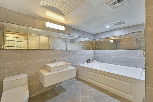 ein Badezimmer mit Badewanne, Toilette und Waschbecken in der Unterkunft Palace Hotel in Ulsan