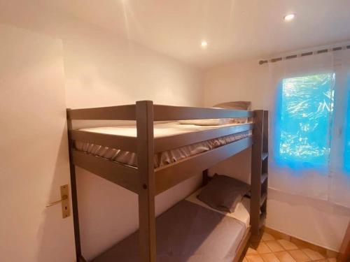 a bunk bed room with two bunk beds and a window at Maison en corse in Santa-Maria-Poggio