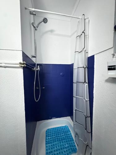 a bathroom with a shower with a blue wall at Atlantic Breeze Apartment in Figueira da Foz