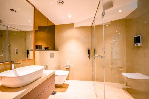 een badkamer met een wastafel en een douche bij Nestlay Suites by TC One in Kozhikode