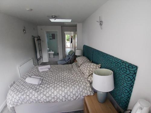 a small bedroom with a bed and a mirror at Ensuite Room with Private Entrance in St. Ives