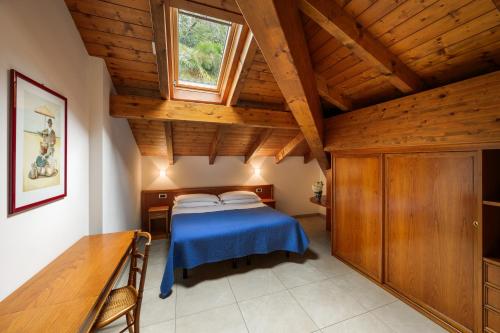 een slaapkamer met een blauw bed en een houten plafond bij Residence L'Ulivo in Bellagio