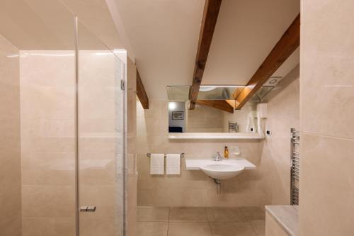 een badkamer met een wastafel en een douche bij Residence L'Ulivo in Bellagio