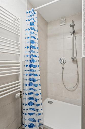 a bathroom with a shower curtain and a tub at Ferienwohnung am Bodensee - nur 10 Minuten zu Fuß zum Strand in Langenargen