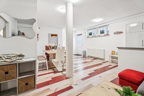 un salon avec des murs blancs et un canapé rouge dans l'établissement Ferienwohnung am Bodensee - nur 10 Minuten zu Fuß zum Strand, à Langenargen