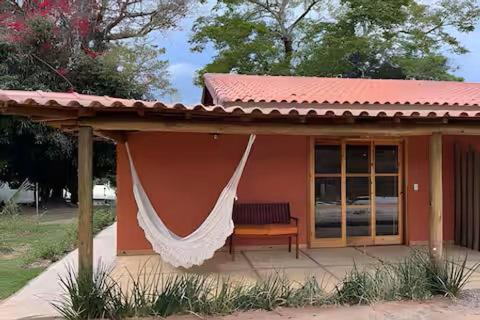 un porche de maison avec un hamac dessus dans l'établissement Sítio Santo Antônio - Chalé com Ofurô, à Atibaia