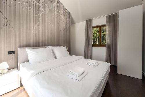 une chambre avec un lit blanc avec deux serviettes dessus dans l'établissement Mediterrane Steinvilla mit Privatpool, toller Aussicht, starkem WiFi, BBQ, à Majkusi