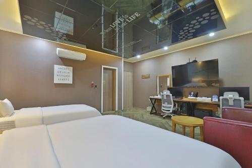 una camera d'albergo con un letto e una scrivania con un computer di Palace Hotel a Ulsan