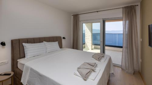 een slaapkamer met een bed en een groot raam bij Villa Sole Komarna by Villas Guide in Klek