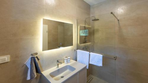 a bathroom with a sink and a shower with a mirror at Villa D Cube by Villas Guide in Duba