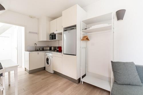 una cucina bianca con frigorifero e tavolo di Studio Hyper centre - Dans Hotel Particulier - Charles le Téméraire a La Celle-sous-Gouzon