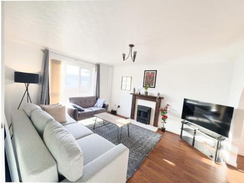 a living room with a white couch and a fireplace at Spacious Newport Home Near ICC & Local Attractions in Newport