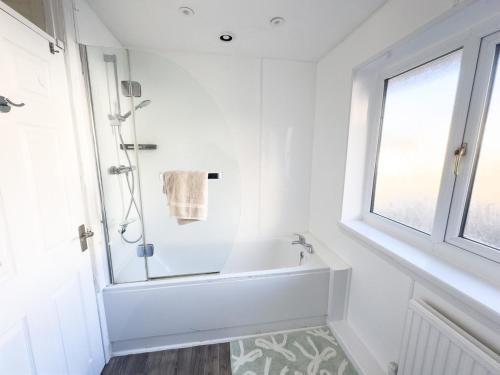 a white bathroom with a shower and a tub at Spacious Newport Home Near ICC & Local Attractions in Newport
