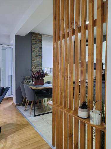 a living room with a wooden partition with a table at Apartman Riva Parking Garaža in Kraljevo