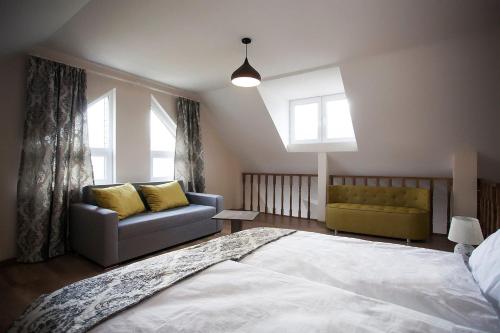 a bedroom with a bed and a couch and windows at Hotel Donata in Gudauri
