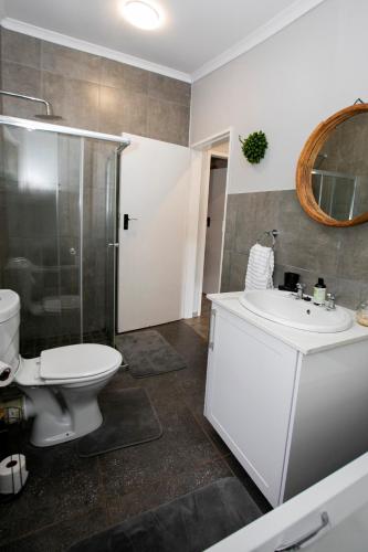 a bathroom with a toilet and a sink and a shower at Buchan's Corner Unit 2 in Hartbeespoort