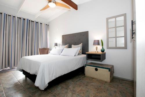 a bedroom with a large white bed and a window at Buchan's Corner Unit 2 in Hartbeespoort