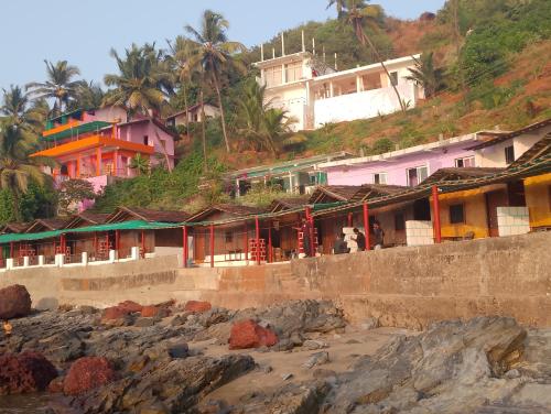 een groep huizen op een heuvel naast het strand bij Sea View Cottages in Arambol
