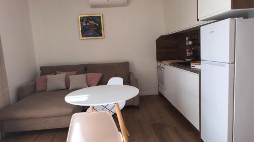 een kleine keuken met een witte tafel en een bank bij Apartman Twins 2 by Villas Guide in Ðurinići