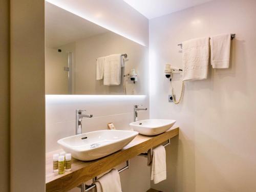 a white bathroom with a sink and a mirror at Ibis Styles Figueres Ronda in Figueres