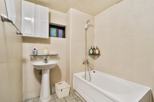 e bagno con vasca bianca, lavandino e vasca. di MIIN Stay a Seul