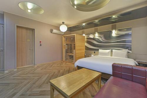 una camera d'albergo con un letto e un divano di Palace Hotel a Ulsan