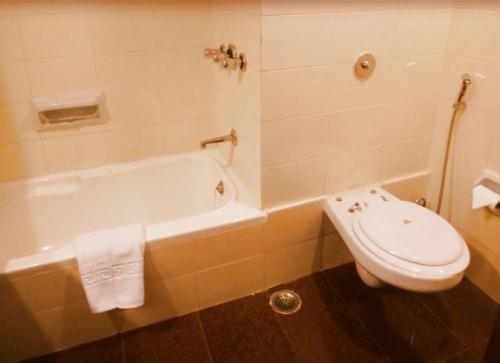 a bathroom with a toilet and a bath tub at Clarks Khajuraho in Khajurāho