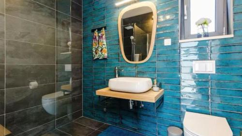 a blue tiled bathroom with a sink and a mirror at Villa Bohemia by Villas Guide in Dubrovnik