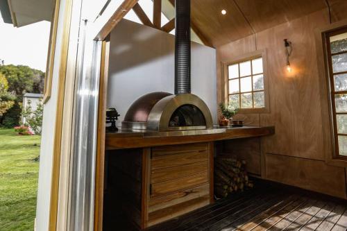 a kitchen in a tiny house with a stove at Galbraith Beach Studio 1 - steps away from beach in Marengo