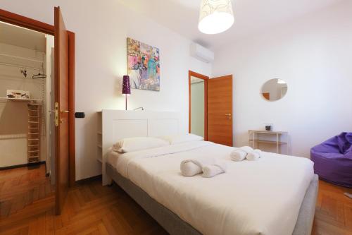 una camera da letto con un grande letto bianco con due cuscini di PrimoPiano - Sporting Mirasole a Opera