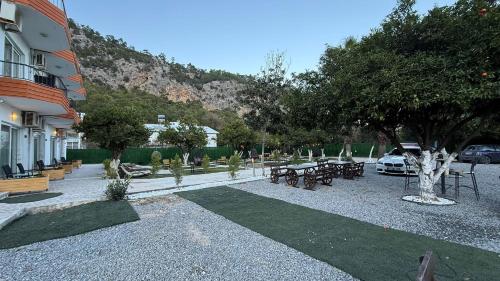 een park met tafels en banken en een gebouw bij Gızlıkoyhotel in Antalya