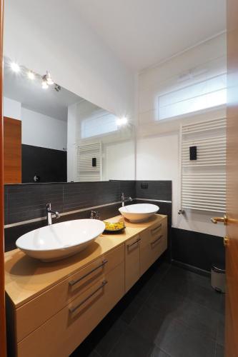 a bathroom with two sinks and a large mirror at PrimoPiano - Sporting Mirasole in Opera