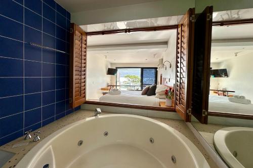 a large bath tub in a bathroom with a bedroom at BlueWater Penthouse GuestSuite 3B in Newport