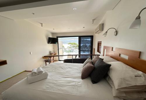 a large white bed in a bedroom with a window at BlueWater Penthouse GuestSuite 3B in Newport