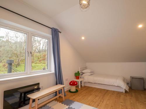 a room with a bed and a fireplace and a window at Faodail House in Portree